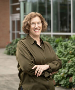 Headshot of Dr. Laura Dunn, Director of the Psychiatric Research Institute, in front of the PRI Building at UAMS