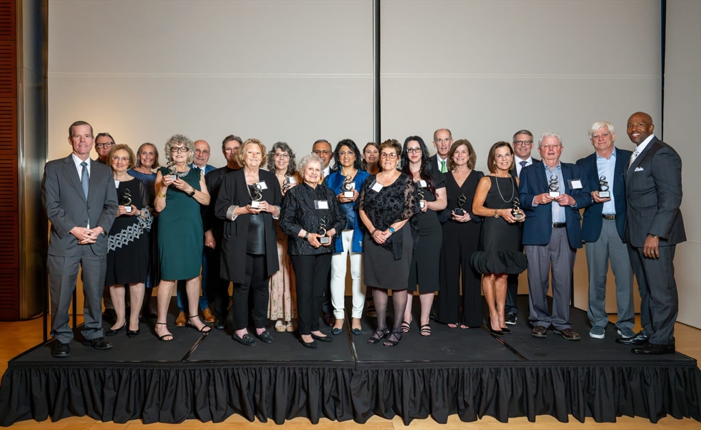 The 2025 inductees of the Society of the Double Helix stand on stage with former Chancellor Patterson, each holding their award
