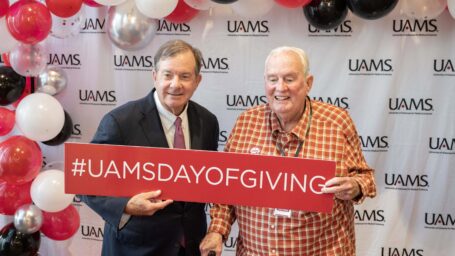 Dr. Barnes and Dr. Westbrook hold up a #UAMSDayofGiving